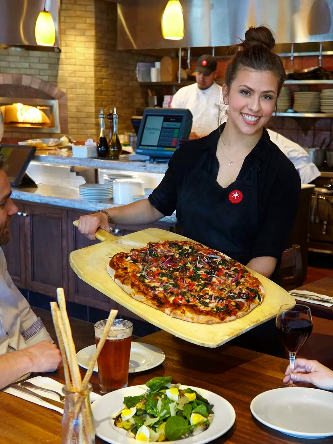 A Tomatina server delivering a freshly made pizza